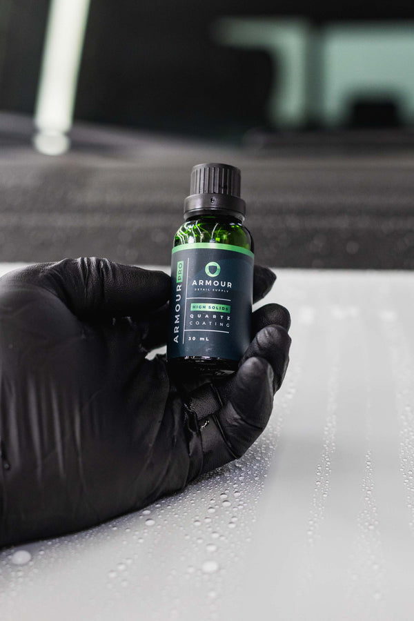 Armour Detail Supply Quartz Pro 30ml Bottle being held in a persons gloved hand.