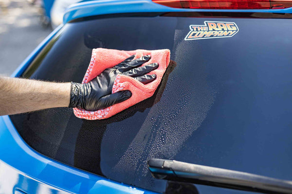 Citrus Twist towel wiping off a blue car window.