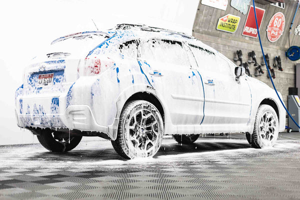 A blue car with soap on it.