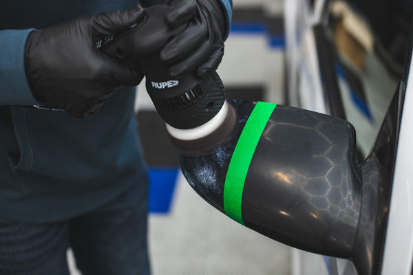 KochChemie OneCut Pad being used on a side mirror for a before and after comparison.
