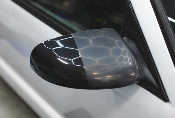 A before and after view of using KochChemie One Cut and Finish on a car side mirror.