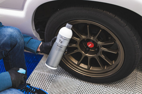 Person cleaning a car's tire with KochChemie Tire Glaze.