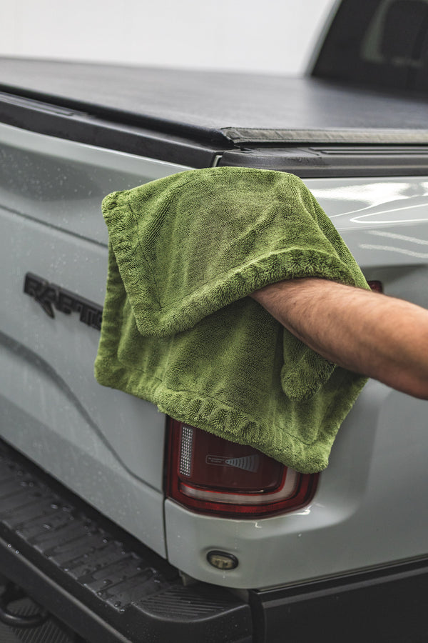 Person cleaning a car with a green m22 towel