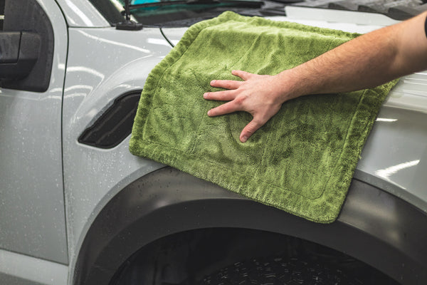 Person cleaning a car with a m22 green towel