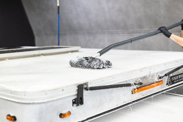 Mitt on a Stick being used to scrub off top of a camper.