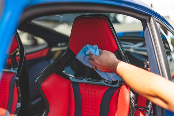 Person cleaning a red car seat with a blue edgeless 300.
