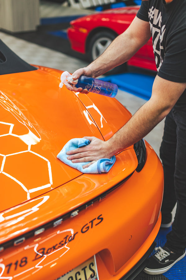 Person cleaning an orange car with Opti-Coat Hyper Seal