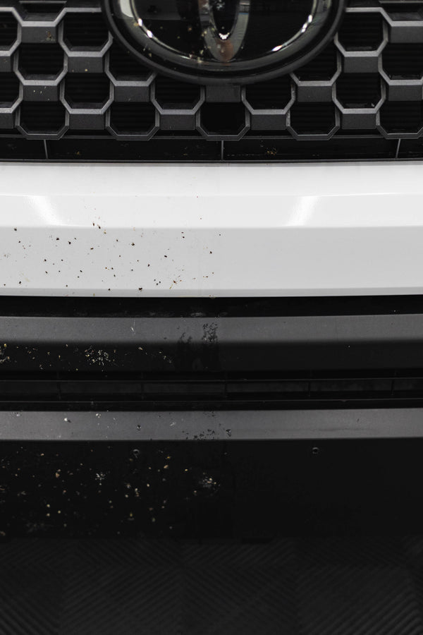 Close-up of a car grille with before and after of using P&S Bug Off.