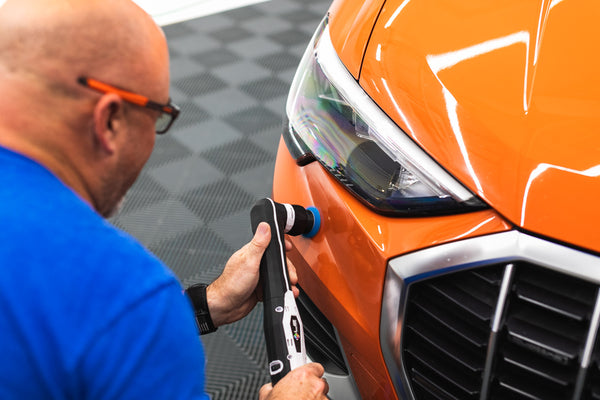 A person using a rupes da coarse pad on a polisher.