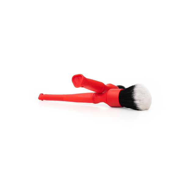 A long and short red Synthetic Detailing Brush on a white background.