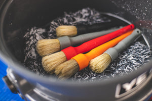 A bucket filled with Boar Hair Brushes in an assortment of colors.