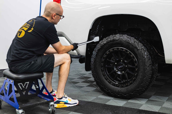 Detail Factory Fender Well Brush Black Ice scrubbing the fender well of a white truck.