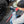 A person holding a Detail Factory Fender Well Brush Red and spraying a KochChemie product on the tire of a white truck.