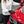 Person cleaning a red car with a black gloved hand with a grey sponge.