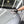 A gloved hand uses a black and white wash mitt, saturated with Koch-Chemie Ceramic Effect Shampoo, to wash the hood of a car.