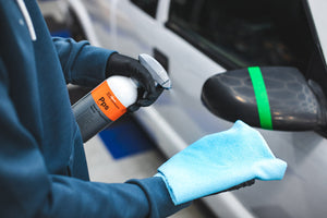 KochChemie Panel Preparation Spray being sprayed onto a blue microfiber towel.