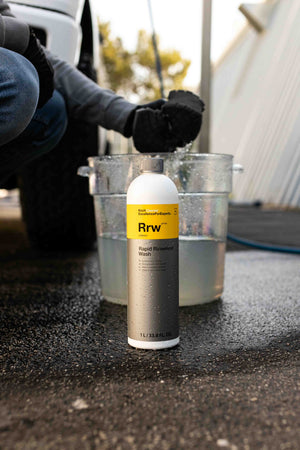 Koch-Chemie Rapid Rinseless Wash 1 Liter bottle in front of a bucket of water. 