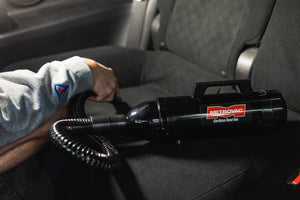 Metrovac Cordless Hand Vac cleaning off the interior seats in a car.