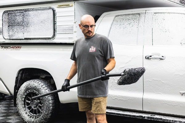 A person holding a mitt on a stick 
