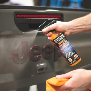 A hand spraying the jeep logo on the back of a jeep with P and S Bead Maker.