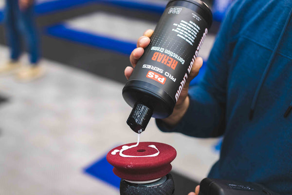 P&S Rehab being poured onto a maroon polishing pad connected to a rupes polisher. 