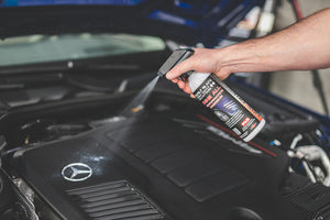 A person spraying the Mercedes logo on top of an engine with P and S Shine All.