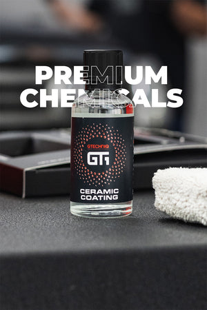A bottle of G11 Ceramic Coating by GechiOS is displayed on a dark surface with a white microfiber cloth and its box in the background. Large white text overlay reads 'PREMIUM CHEMICALS'.