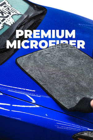 Grey microfiber towel on a blue car with 'PREMIUM MICROFIBER' text.