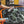 A closeup of a person spraying the front windshield of an orange Porsche with Opti-Coat Glass Cleaner.