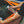 A person spraying the window of an orange porsche with Opti-Coat Glass Cleaner. 