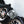 A person dangling a foamy Ultra Wheel Mitt on their index finger with a background of two blurred tires.